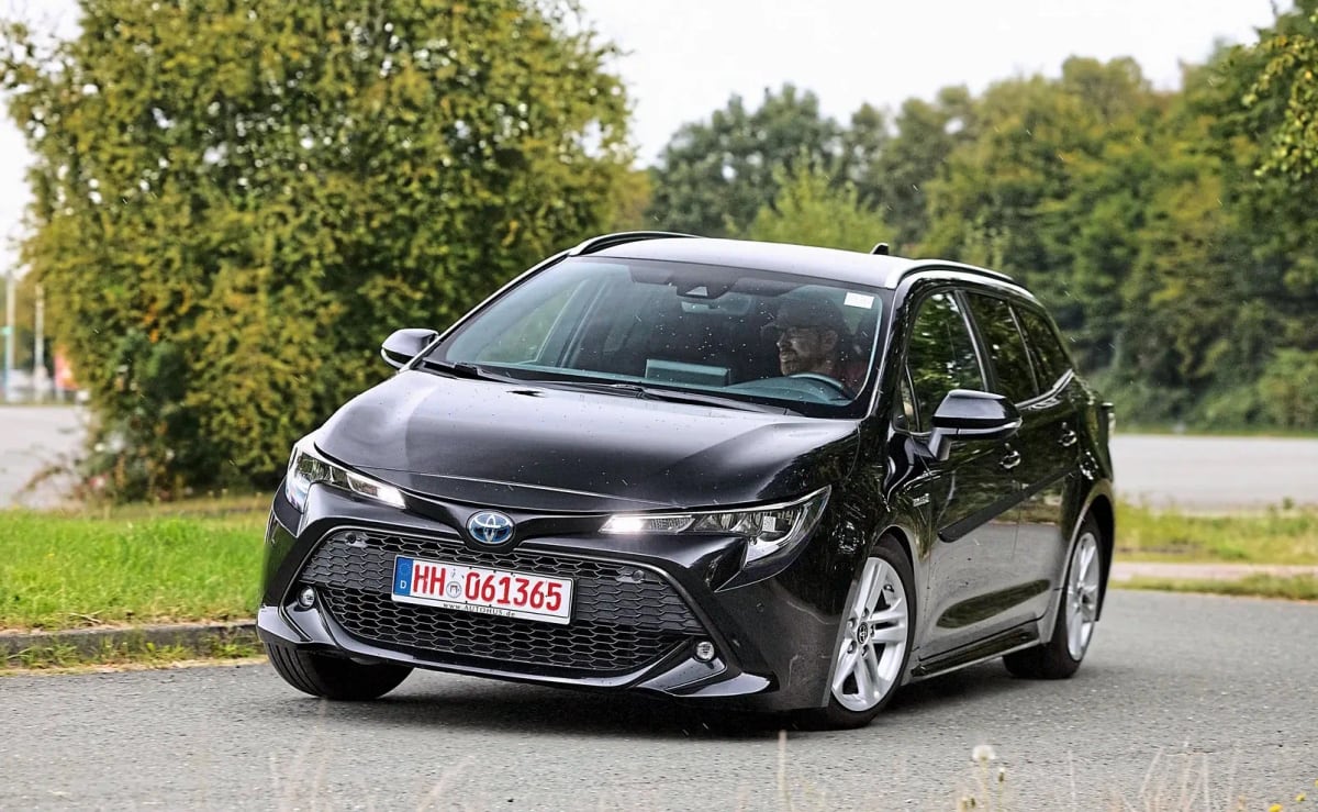 Черна Toyota Corolla Touring Sports в движение по мокър асфалт