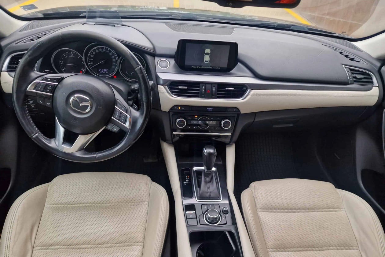 Табло и предни седалки на Mazda 6 с бежова кожа, автоматична скоростна кутия и екран на централната конзола